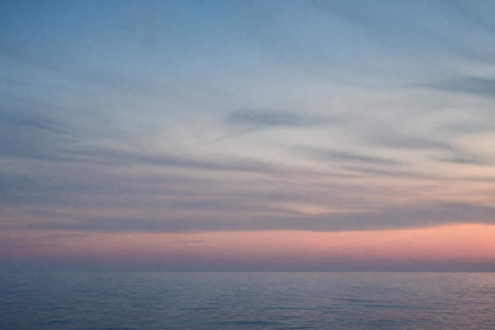 Horizonte de mar aberto ao amanhecer, apenas linha d'água e céu em camadas